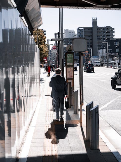 A businessman walking down a city sidewalk during the day.