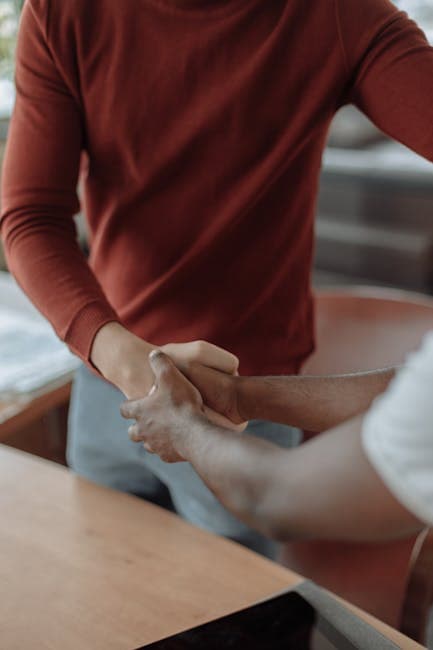 Close-up of two businessmen shaking hands, symbolizing partnership and teamwork.