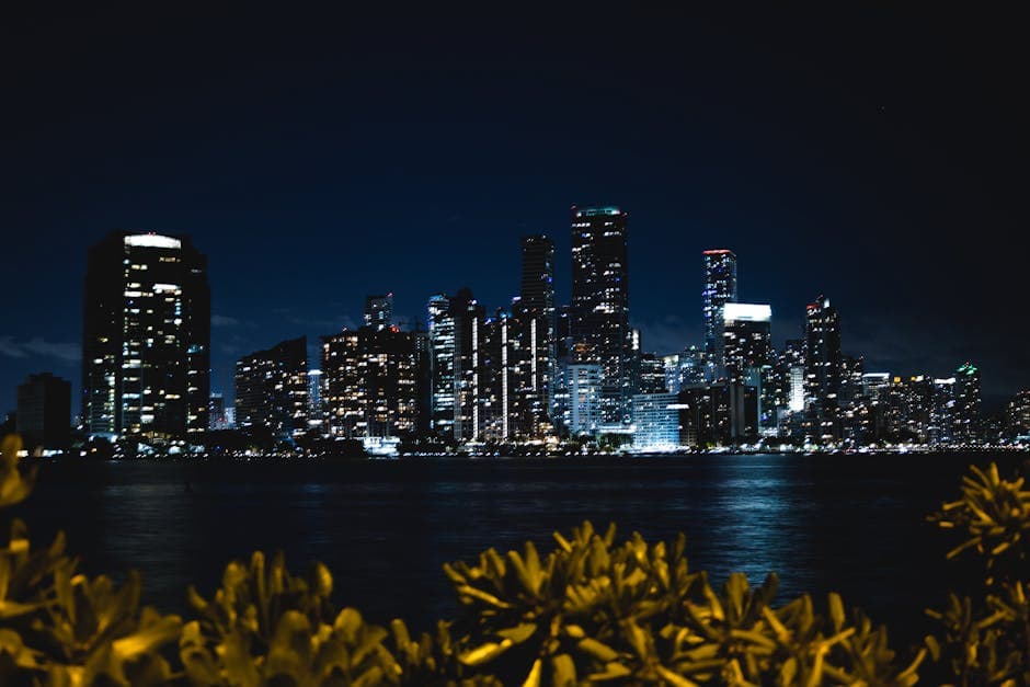 Captivating night view of Miami's skyline with shimmering city lights reflecting on the water.