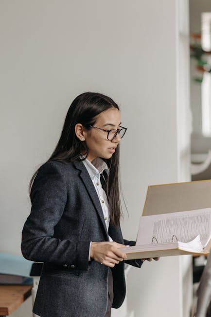 Confident businesswoman analyzing documents indoors in an office setting.