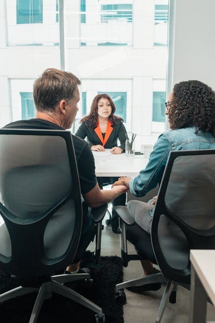 A couple holding hands during a business consultation in a modern office setting.