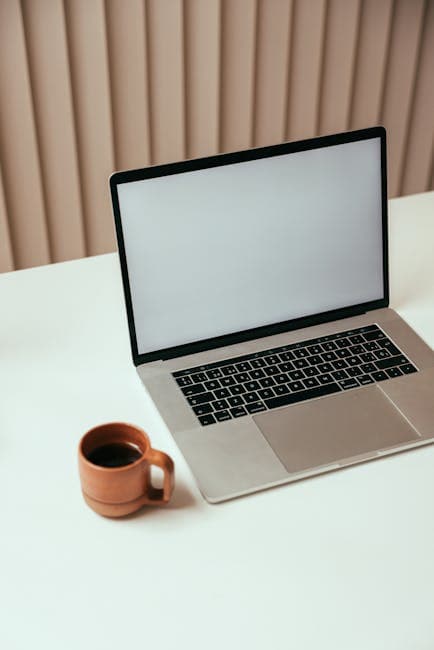 A minimalist workspace with a laptop and a cup of coffee on a clean desk, perfect for technology or productivity themes.