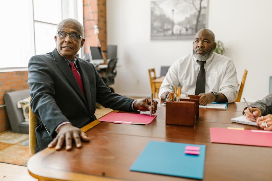 Senior businessmen in a modern office engaged in a collaborative meeting.